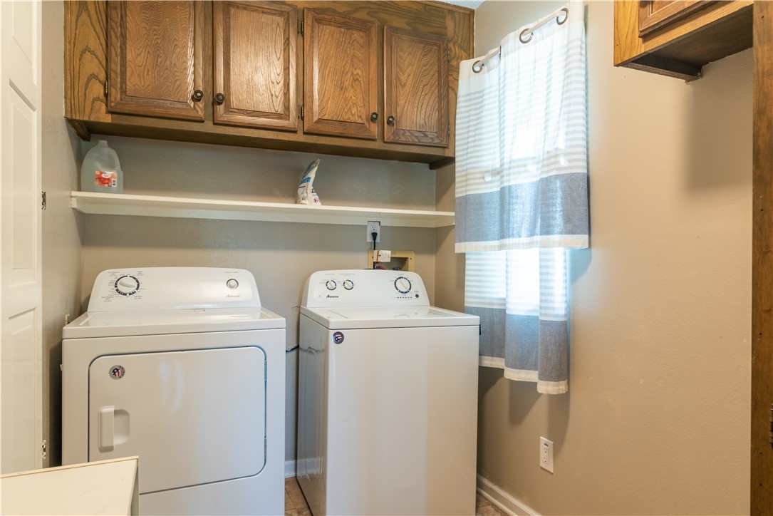 Photo #23 The laundry room is located inside with shelving and upper cabinetry for general storage.