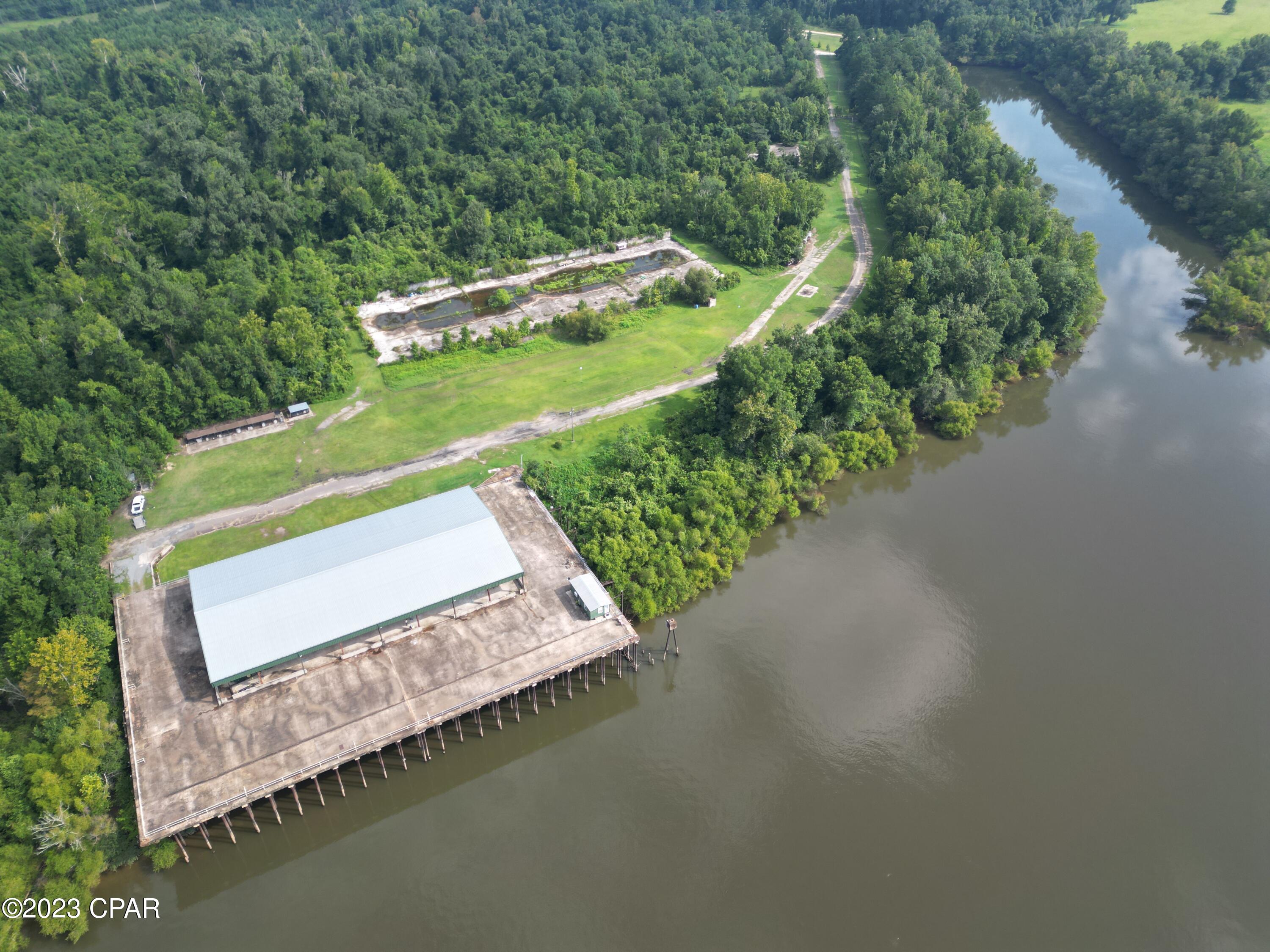 Location, location, location! Welcome to river life!  This premier river retreat is your opportunity to own a part of paradise with 1,600 feet of waterfront on the Apalachicola River (over 1,100 feet of basin waterfront).  With a 1/4 mile entrance and breathtaking views, this private 54+/- acres is truly a rare gem! It is only one of two privately owned riverfront properties in Jackson County.  The Apalachicola River is one of North Florida's most scenic rivers and offers the highest diversity of freshwater fish species in the state, resulting in some of the best fishing in the Florida Panhandle.  On any given day, you can catch black bass, hybrids, striped bass, white bass, bluegill, shell cracker, crappy, channel cat or flatheads right from the bank.  Or, jump in your boat and take a short cruise down the river where you can gig flounder - right off of a sandbar!  The property is located approximately 2 miles below Jim Woodruff Dam, separating Lake Seminole from the Apalachicola River.  With over 37,000 acres, Lake Seminole offers anglers some of the most prolific bass fishing in Florida, Georgia, and Alabama.  An easily accessible boat ramp at the front of the property allows travel by boat to the Gulf of Mexico or you can navigate through the lochs at the Dam and enter Lake Seminole.  From this point, you can continue enjoying the endless recreational opportunities river life has to offer as you work your way to the Chattahoochee River, Flint River, and Spring Creek into Georgia.  Along the river bank there is an abundance of wildlife including white tail deer and bald eagles.  And at dusk the owls begin their symphony of calls.  With this in mind, it is easy to imagine life immersed in the beauty of the river.  Another impressive feature of the property is a 14' X 30' tiny home that sits on an expansive 300' X 200' concrete platform offering pristine views over the river.  A 200' X 100' metal barn is also located on the platform that includes 5 camper hookups and a 5th wheel camper with three slide-outs and a king size bed.  Additionally, two acres of the property is zoned commercial - opening up endless opportunities for a business venture that might include an RV park, wedding venue, or campsite.  This hidden gem is truly a coveted find that offers privacy, adventure, and immediate access to a fisherman's paradise.  Surrounded by stunning natural beauty, it is the perfect opportunity to establish a unique and beautiful homesite.  Call today to schedule a private showing.Additional information:*Located approximately two miles below Jim Woodruff Dam - the dam impounds 37,500 acre Lake Seminole on the common border of Florida and Georgia*Established septic and 12 inch well *County owned and maintained boat ramp on site*Paved road access* Over 1,600 feet of River frontage and 1,100 feet of basin waterfront that is sold as part of this property*50 miles to Tallahassee, FL