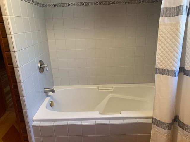 Upstairs hall bathroom has a soaking tub/shower combo