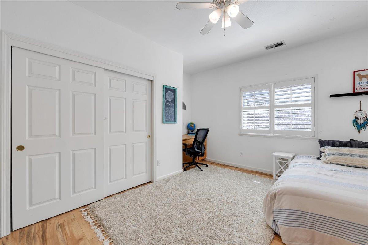 HUGE guest bedroom # 1. Built-in desk, shutters, ceiling fan, wood-look flooring and more!