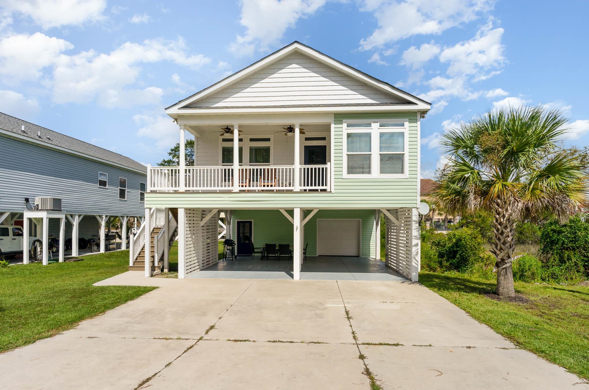 This Prestine Raised Beach home in the great Little River area. You will love all the natural light that the open floor plan offers.  Relax in the living room with the shiplap accent wall with fireplace on the cool Carolina evenings. There are custom touches throughout the home crown molding, board and batten trim, decorative tile flooring, recess lighting and the beautiful flooring throughout. The kitchen offers SS appliances, granite countertops and tile backsplash.  The spacious master bedroom offers a private bath with his and her sinks and a generous Walk-in closet and access to the rear deck where you can enjoy a morning coffee enjoying magnificent marsh and the intercoastal waterway view or relax in your hot tub and watch the boats go by.  Mins for everything the area offers, shopping, dining and best of all just it's away from the white sandy beaches of the Grand Strand.
