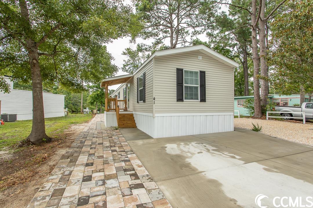this is a show stopper! gorgeous 2 bed 2 bath home built in 2022 located on a pond with amazing views! home is being sold furnished and the furnishings are beautiful! the curb appeal is stunning! concrete pad driveway and walk way to the right side of the home. up the stairs to a 3.5 x 34-foot covered walk way deck around the side of the home to the screened in porch that overlooks the pond. the screened porch has a vaulted ceiling with amazing views of the water. this is a great place to relax or entertain! around the other side of the home is an oversized brick paver walkway that runs the length of the home around back to a wonderful patio! hardscaping and landscaping complete the curb appeal for this amazing home! there are stairs that take you to a covered landing and into the front door. walk through the door into the beautifully decorated family room! plenty of seating for all. the kitchen offers ss appliances, recessed lighting, white cabinets and a glass back splash. luxury vinyl plank flooring throughout the home, crown molding, sheet rock walls, chair rails and all walls are painted a beautiful grey! ceiling fans in the family room, master bedroom and the screened in porch! the master bedroom has a nice size walk-in closet. the spacious master bathroom has a garden tub, separate shower 2 vanities with plenty of room to move around. the guest bedroom has a doble closet. this home is breathtaking! all this is located minutes to the beach, famous marsh walk, dining, shopping, golfing and so much more!