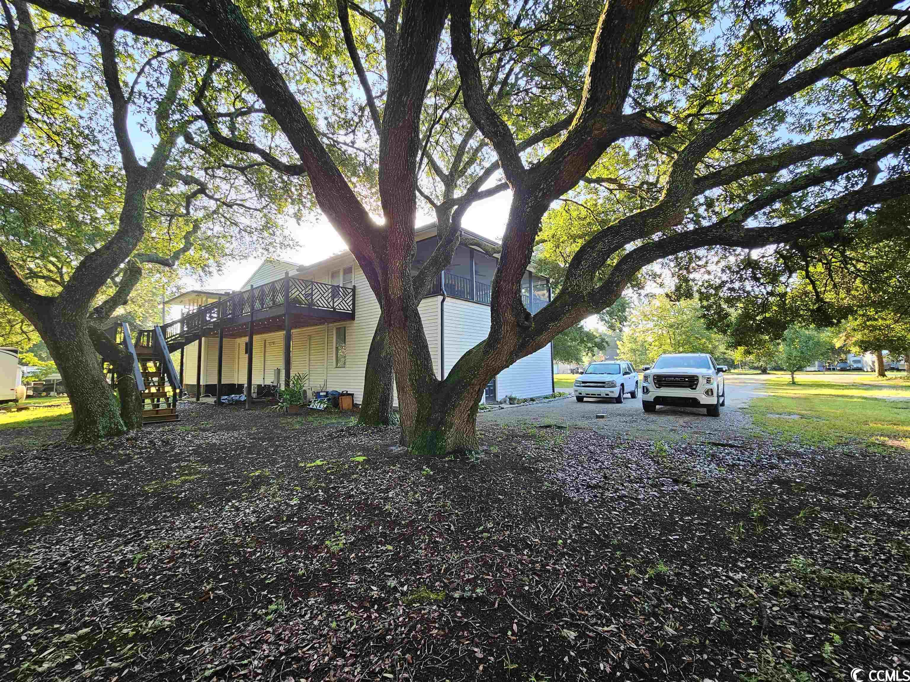 the best of yesterday and today is featured with this home at 4426 old kings hwy. centrally located between the waccamaw river and the inlet, this home has a little bit of it all sitting on just over an acre of land. the original part of the home on the second level is beautiful old beach house built in 1958. construction of the home was knotty pine framing including all of the finish work. pine walls, ceilings, floors, doors, cabinets, and trim. the screened porch on the top floor has a breeze just about any time of day. the home had an unmatched engineering cradle system when it was relocated to the current site. the bottom floor was renovated in 2020 has is its own separate living quarters with a private entrance. at the same all new siding, metal roof, ac units, and, and back porch was completed, as well. the home is currently used as a two-family second home. both the 1st and 2nd level are very sunny, open floor plans. downstairs is 2 bedrooms, 1.5 bathrooms, and, upstairs is 2 bedrooms, 1 bathroom. the home sits on a double lot and has a very expansive driveway and backyard. the driveway is a full circle from each property line with parking capacity for anything you have. there is no hoa and plenty of room for boats, rvs, trailers, and much more in the backyard alone. there is plenty of shade under all the majestic oaks that line throughout the property. the downstairs of the home features a commercial kitchen with workshop, and full bathroom along with a 50 amp service on the exterior. it is less than a mile golf cart ride to either the marshwalk or wacca wache marina and a two mile bike ride to huntington beach state park. there are no rental restrictions on the property.