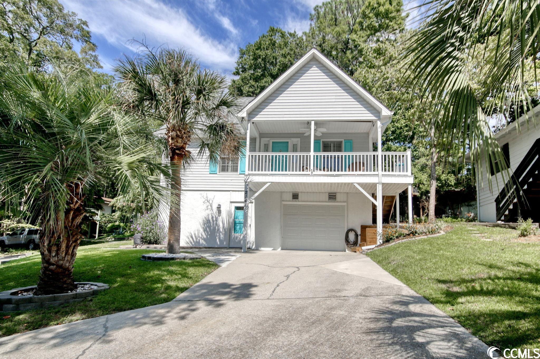 this cheerful beach house is situated on a corner lot, high on a hill covered with palm trees, in windjammer village, a gated intracoastal waterway community in little river (just south of the nc line).  the large inviting front porch welcomes you into an open kitchen, living, dining area full of natural light from the many windows.  the kitchen offers abundant cabinet and drawer space with long counter/breakfast bar and stainless steel appliances (dishwasher and disposal replaced august 2023).  the focal point of of this entire area is the recently added stone electric fireplace in the living room.  simply stunning! the washer/dryer closet, a bedroom, and full bath with linen closet and tub/shower complete this level.  the second level boasts another bedroom, bath with walk in shower and another linen closet, as well as a loft that can serve multiple purposes - another bedroom area, office, fitness, den...  the basement level is huge!  plenty of storage room, a single car garage, another space for a golf cart, and a workshop.  this space could be finished off to make more real living space.  other added benefits of this home include volume ceilings; plantation shutters on the main level; a fenced side yard; a concrete driveway in the front and gravel parking in the rear; new roof, garage door and hvac in 2019; and new water heater in 2022.  this has been a meticulously maintained second home and has been loved by its current owners.  community amenities include clubhouse, pool, pier, tennis and pickle ball courts, and new boat ramp.  there is boat/trailer storage, but you must inquire and there is a gate from the community leading to the beautiful walking paths of the adjacent vereen gardens.  just minutes to the famous restaurants in both little river and calabash.  convenient to golf, entertainment, marinas, fishing, shopping, medical facilities, and more!  measurements are approximate and not guaranteed.  buyer is responsible for verification.