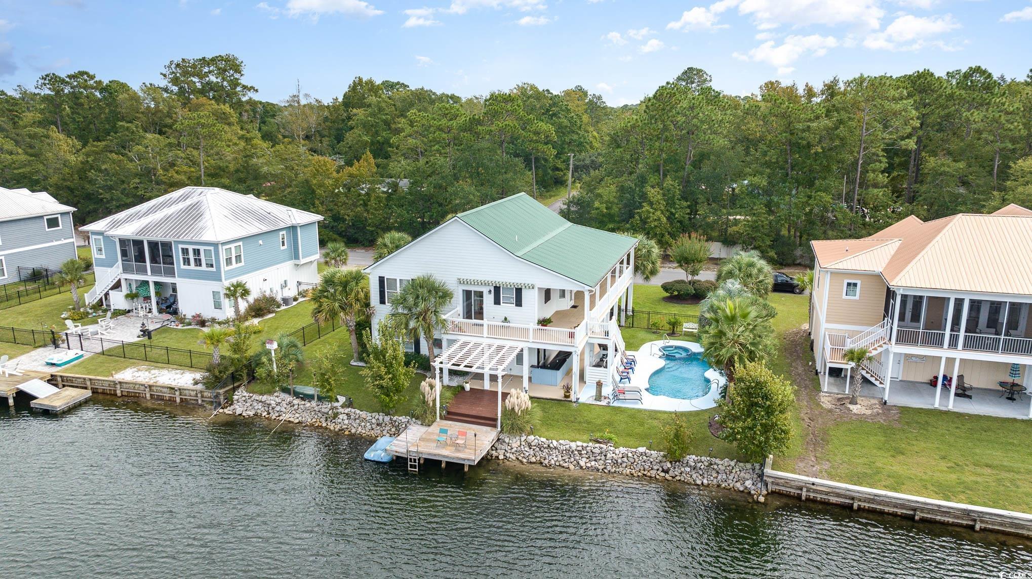 welcome to your dream home in the picturesque woodlawn plantation, where every day feels like a serene getaway. nestled in a gated community on a sprawling 20-acre lake, this 4-bedroom, 3-bathroom raised home boasts tons of incredible features that will leave you enchanted. step onto the back porch and you'll be greeted by breathtaking views of the tranquil lake. it's the perfect spot to enjoy your morning coffee or unwind after a long day. the feeling is akin to sitting on your own private yacht, with the lake's crystal-clear waters right at your doorstep. as you enter the home, you'll find an interior that boasts warmth and comfort. hardwood flooring graces the main living areas, creating an inviting ambiance. the bedrooms offer 9 ft doors, and plush carpeting for cozy nights. the bathrooms feature elegant tile work and granite countertops. for the culinary enthusiast, this kitchen offers an abundance of counter and cabinet space, providing ample room for storage and meal preparation. you'll never have to worry about running out of room for your kitchen essentials! this upscale kitchen also boasts granite countertops, stunning tile backsplash, stainless steel appliances and views of the lake while you are preparing your meals. the ground floor is a haven for versatility. it features ample garage and storage space for all your toys and hobbies or projects. additionally, a spacious family room opens up the possibility of a mother-in-law suite or a fantastic game/bonus room. the home's curb appeal is enhanced by its well-maintained private pool and manicured landscaping. woodlawn plantation offers more than just a beautiful home; it offers a lifestyle. the 20-acre lake is a paradise for outdoor enthusiasts. whether it's pedal boating, sailing, kayaking, fishing, or swimming, the lake has it all. plus, it's stocked with fish for those who enjoy a bit of angling. minutes from your home, you'll find the atlantic ocean, intracoastal waterway, and the famous murrells inlet marshwalk. it's the perfect blend of tranquility and accessibility, allowing you to savor the best of both worlds. lastly, the low hoa ensures that you can enjoy all these amenities without breaking the bank! don't miss this incredible opportunity to make this beautiful lakefront home your own. schedule a showing today and discover the true meaning of peaceful, lakeside living.