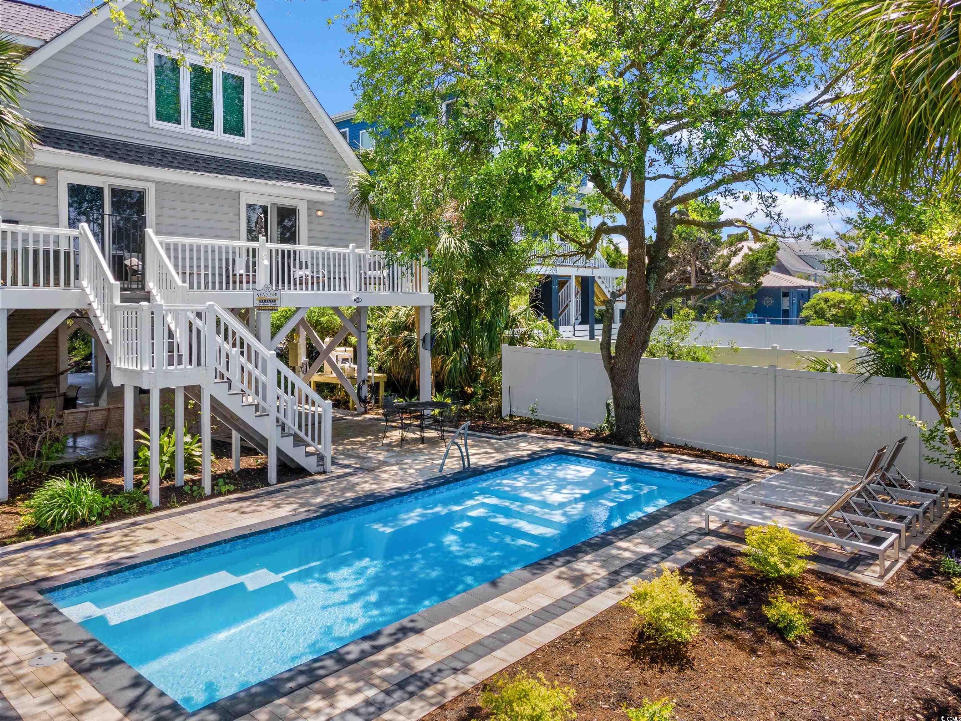 this beach cottage is ideally located on the garden city peninsula between the atlantic ocean and murrells inlet.  enjoy inlet views, easy beach access only a block away, and sea breeze from the second-floor ocean-forward deck.  the floorplan includes 4 bedrooms, 3 bathrooms, 2 living areas, and a full-size laundry room that is set-up to accommodate 12 guests.  you and your guests will love the backyard that features a fenced private fiberglass pool with paver deck that was installed less than a year ago. other features to note are hardwood floors, a fireplace, a screened porch, two open decks, kitchen with granite backsplash & bar top, an enclosed outdoor shower, outside storage rooms, and parking under house.  being sold fully furnished - rental ready, including a golf cart!  great vacation rental investment.  call to schedule a showing today!