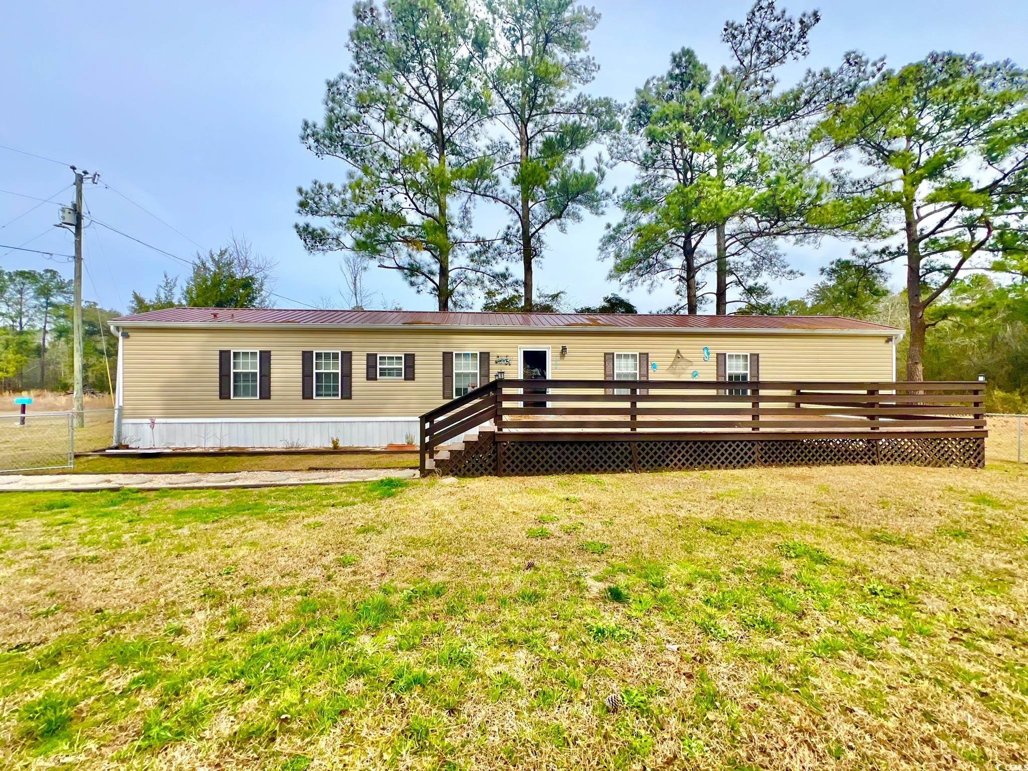 welcome to your slice of southern paradise at 100 minister ln., georgetown, sc! step into a storybook setting where dreams of tranquil living come to life! nestled on 2.36 sprawling acres of prime south carolina land, this charming 3-bedroom, 2-bathroom manufactured home—located in the sampit area of georgetown—is more than just a dwelling; it's a haven where memories are made and legacies begin. as you drive into the property, you’re meet with towering pines surrounding the home, which leaves you feeling the cares of the world melt away. imagine waking up each morning to the soft chirping of birds and the promise of a new day dawning over your very own piece of paradise. step inside to discover a meticulously maintained interior boasting 1,200 square feet of cozy living space. freshly updated with new carpet underfoot and a gleaming new metal roof overhead, this home exudes warmth and comfort at every turn. whether you're hosting family gatherings in the living room or whipping up culinary delights in the kitchen, every moment here is infused with the essence of southern hospitality. outside, the magic continues with a fenced yard offering plenty of space for children and pets to play freely. picture yourself unwinding on the expansive front deck as you sip sweet tea and watch the sunset paint the sky in hues of pink and gold. for those seeking adventure, you'll find no shortage of excitement just a stone's throw away. indulge in a day of shopping and dining in charming georgetown—only 18 minutes away, or pack a picnic and head to myrtle beach for sun, surf, and endless entertainment—only 1 hour and 5 minutes away! whether you're yearning for a peaceful retreat or a home base for endless adventures, 100 minister ln. offers the best of both worlds. don't miss your chance to make this idyllic southern sanctuary your own. schedule your showing today and start living the lowcountry lifestyle you've always dreamed of!