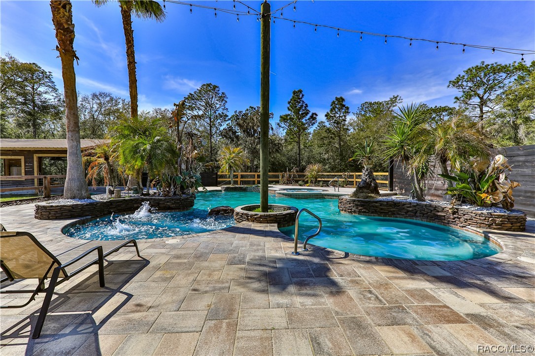 This home will have you living the resort lifestyle everyday!
3.87 acres fenced, living 2,255 sqft, 2,970 under roof, 3/2/2, new roof, new pool pumps, new garage door, new fridge, 6 burner gas stove with griddle, pot filler over stove, tons of cabinets/quartz and granite, outside quartz bar top, projector with remote drop down screen, timber front entrance, saltwater pool, jacuzzi with 3 jet packs and wrap around bench seating, pole barn with electric, 3K sqft of pavers, over 11 ft deep pool, pool sun shelf layout area with 3 bubblers, pool waterfall, custom walk in showers, gas tankless hot water heater, gas fireplace, outdoor pool shower with private fence, too much to mention all the extras this home has! 
*Central location: about an hour from Tampa & Clearwater. An hour and 20 minutes to Orlando. 
*Crystal River (known for manatees) and Rainbow River (amazing kayaking) are about 25 and 35 minutes away. 
*Lake Bradley is a 5 minute drive to enjoy boating and fishing