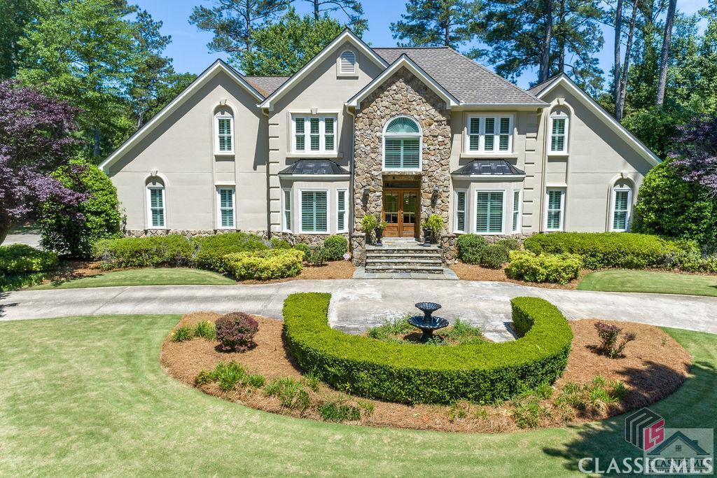 This stunning estate home has an incredible street presence and overlooks hole #6 of the Jennings Mill golf course! You will thoroughly enjoy the large rear patio banded in stone for entertaining and catching a glimpse of the golfers. The interior features 4 bedrooms and 3.5 baths, plus a large bonus room over a 3 car garage. The formal living room and dining room flank either side of the two story foyer.  The graciously sized kitchen with island, an abundance of cabinets, bar and desk area boasts quartz countertops and an oversized dining area which has a wall of windows overlooking the meticulously groomed rear lawn! The vaulted great room has a wood burning fireplace and handsome wet bar and boasts french doors leading to the rear patio. The master bedroom and bath are located on the main level, and the bathroom has been renovated with a huge tile shower with dual shower heads and frameless glass door! Three additional bedrooms, plus the bonus room and two full baths are located on the upper level. One bedroom has an en suite bath for private guest quarters! Conveniently, there are two staircases, one leading from the kitchen dining area as well as one from the two story foyer. There is a very spacious laundry room with a utility sink, cabinetry and space for a second refrigerator. Heavy crown and shadowbox molding, hardwood floors throughout the main living areas and plantation shutters further enhance this elegant home. Some recent upgrades include: central vacuum, new roof, new main level furnace, renovated master shower, tile floors in baths, new counters and sinks in baths and new windows on front of home. The house also features a whole house air filtration system. You don't want to miss out on this incredible home!