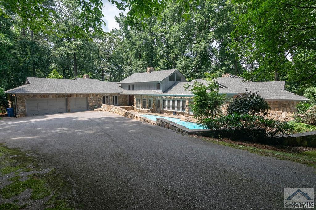 This custom built estate is situated on a private 5.28 acre lot with a walkway and dock overlooking the Oconee River! With 4 BD and 3.5 BA on the main level, and an additional 2 BD and 1.5 BA in the finished basement, this property is perfect for those needing an in law suite or private guest quarters. Buyers will be taken back with the stunning flagstone patio and pool at the front of the home, leading to the double stained wood front door. The vaulted foyer overlooks the formal Dining Room and expansive Great Room with vaulted ceilings and fireplace. Numerous windows provide stunning natural light to both of these rooms, as do the front windows overlooking the pool. The kitchen features a large cooktop island, double wall ovens, ample custom cabinets and an extra sink. In addition, a butlers pantry connects to the Dining Room for your entertaining needs. The large Owner's Suite can be found on the main level and features vaulted ceilings, custom built ins, fireplace, private deck and a large bath with double vanities and jetted tub with a separate shower. The main level also features 3 additional guest bedrooms, one with an en suite bath, and the other two sharing a Jack and Jill. All bedrooms are graciously sized. The handsome family room has cherry paneled walls, built in shelving, large window seat and a gas log fireplace. Access to the rear deck is perfect for all of your grilling needs. Also located on the main level are two spacious home offices with built-in bookshelves and French doors leading to a stone patio, a great laundry room with utility sink and powder room. The terrace level boasts a wall of custom book shelves and wet bar in the oversized rec area, as well as a stone fire place. The mother in law suite has a den, kitchen, bedroom and full bath, as well as a breakfast room. There is an additional bedroom and 1/2 bath in the basement that could easily double as a great work out room! The unfinished storage area is perfect for storing lawn and pool equipment and has interior and exterior access. This is a very special property zoned RS-25 with incredible river frontage!