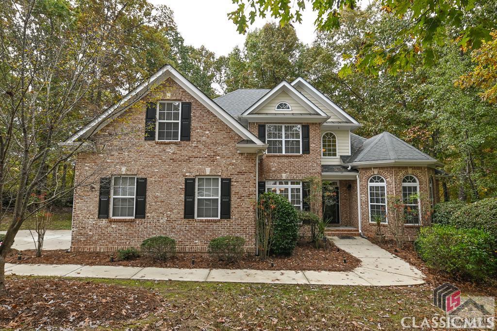 Beautiful, all brick home in the desirable St Charles neighborhood, where homes rarely come on the market! This home features 5 bedrooms and 3 full bathrooms. The main level of this home plan has a 2-story foyer and great room with a fireplace and has hardwoods throughout the main area. The great room comes equipped with a wet bar with glass cabinets and a wine rack for entertaining. The breakfast area off the kitchen is surrounded by windows and a glass door to the exterior deck overlooking the wooded backyard with a view of the neighborhood pond. The kitchen has plenty of space to cook with granite counters and a breakfast bar. Upgraded lighting package, recessed lighting, heavy crown & molding details throughout the home. Owner's suite is on the main floor and features a trey ceiling, sitting area, two closets and carpet flooring. Owner's bath is a relaxing retreat with jetted tub and vaulted ceiling. The laundry room, extra bedroom and a full bathroom round out the 1st floor. Upstairs there are 3 bedrooms (one designed for GA Dawg fans) and a full bath. Two level decks on the rear of the home, one of them has a hot tub that overlooks a beautiful wooded & fenced yard.