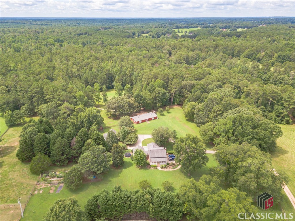 Sprawling 19.81 Acre Farm that backs right up to Hard Labor Creek State Park. The Main House features a large Eat in Kitchen w/Double Ovens/Stainless Steel Appliances**Living Room w/Built in Bookcases/Wood Burning insert**Formal Dining Room**Owners Suite on Main Level w/Walk in Closet/Dual Vanities**Two additional Bedrooms and one additional full bath upstairs**Full Finished Daylight Basement featuring 2 bedrooms/1 Full Bathroom/Eat in Full Kitchen/Living Room w/Fireplace/Laundry Room/Driveway access**Covered Back Porch & Rocking Chair Front porch. The Guest Cottage features 2 Bedrooms w/Full Bathroom & Living Room/Private Back Porch.24X70 Barn with plans for a 2 bedroom/2 Full Bathroom/full Kitchen Living Space(Central HVAC exists and new wiring & plumbing roughed in). Beyond the Barn through the pasture is an additional Barn with a finished room above it**additional Workshop/Storage Building**Additional Horse Corral. Plenty of Fenced area for all your livestock. Conveniently located between Monroe & Social Circle. Please come take a look.