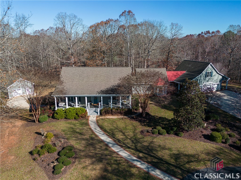 This custom home is located on 67+ acres of privacy in Oconee County! Literally just 15 minutes to downtown Watkinsville and Oconee schools you just can't beat this location.  This is the perfect horse property with several fenced pasture areas, barn with interior and exterior access for stalls, tack room, grooming area and a separate wash rack.  There are plenty of wooded acres for privacy and great trails for riding on and there is a creek along the rear of the property. There is also a separate barn for all your farm equipment and a separate detached garage perfect for a studio space or hobby barn.  This warm and inviting home is open and bright from the moment you step inside off the rocking chair front porch! The open foyer space leads to a formal dining room with wet bar, huge great room with an abundance of windows, a fireplace for relaxing by and an updated open concept kitchen with newer appliances including two dishwashers, double wall ovens, a gas cooktop and a spacious walk in pantry.  Tons of cabinet and counter space make this kitchen a cook's dream!  The owners suite is located on the main level and features a separate sitting room, two walk in closets and an updated bath with separate shower, claw foot tub and double vanities.  There are two half baths, a separate den or perfect home office on the main, a built in command center off the hallway, large mudroom with access to the attached 3 car garage and a second porch.  Above the garage is the 4h bedroom suite, with its own kitchenette and full bath as well as large closet.  This would make an ideal teen suite or even a farm caretakers quarters. The basement is unfinished but currently set up as workshop space, and there is a finished office or man cave  as well as an additional garage area with separate door.  This is one property not to miss! The property is enrolled in the conservation use program.