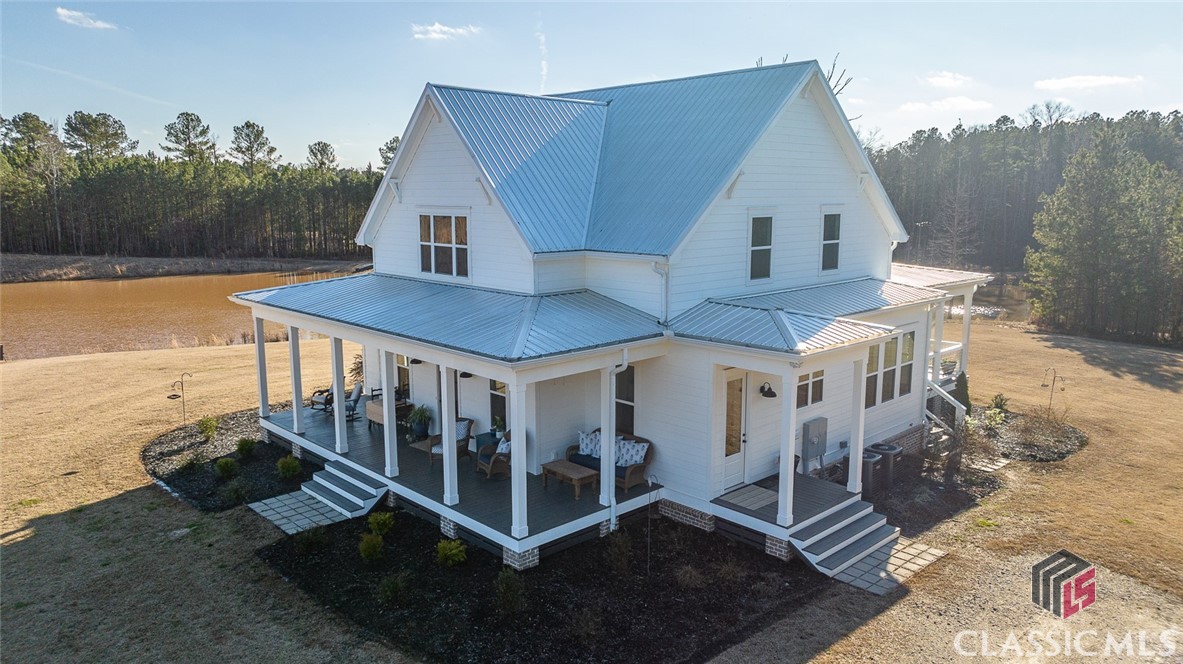 Complete privacy on twenty acres in Oconee County in a showcase home built in 2020 with just over 3,000 sq feet.  Every window looks out over your land with views of sky, hardwoods, ponds, and wildlife. The home's layout compliments the openness of the property with its vistas of natural light, shiplap walls, buttery oak flooring, and every design selection made with beauty and function in mind. The gourmet kitchen with a 6-burner gas range has a centered island with room for 6 chairs. Kitchen also has a farmhouse sink and a pantry that will get you through any occasion.  The dining area is centrally located so friends and family never have to miss a touchdown or a compliment. Owner's suite is on main with a slipper tub and custom closet.  Upstairs has a second living space with multiple closets. Three bedrooms are also upstairs. Two bedrooms have private vanities and share a slipper tub and tiled shower.  The third bathroom is a full-bath and accommodates the entertainment space and the third bedroom. The upstairs is as beautiful and thoughtfully appointed as the main floor with no carpet in the home.  Additional features include: foam insulation in crawlspace, attic, and exterior walls, wrap around porch with pond views and brick fireplace, 6 panel doors, winding gravel driveway with custom gate, screens on windows (imagine opening windows for a cross breeze!), rolling pasture for horses, and designer-inspired finishes. Equipped with a cell booster, which ensures full bars on both AT&T and Verizon towers. 2019 Massey Ferguson tractor and all attachments included with the sale of the home. Also included is a stick built 10x10 wired storage building with water supply. The property has two wells and sprinkler system.