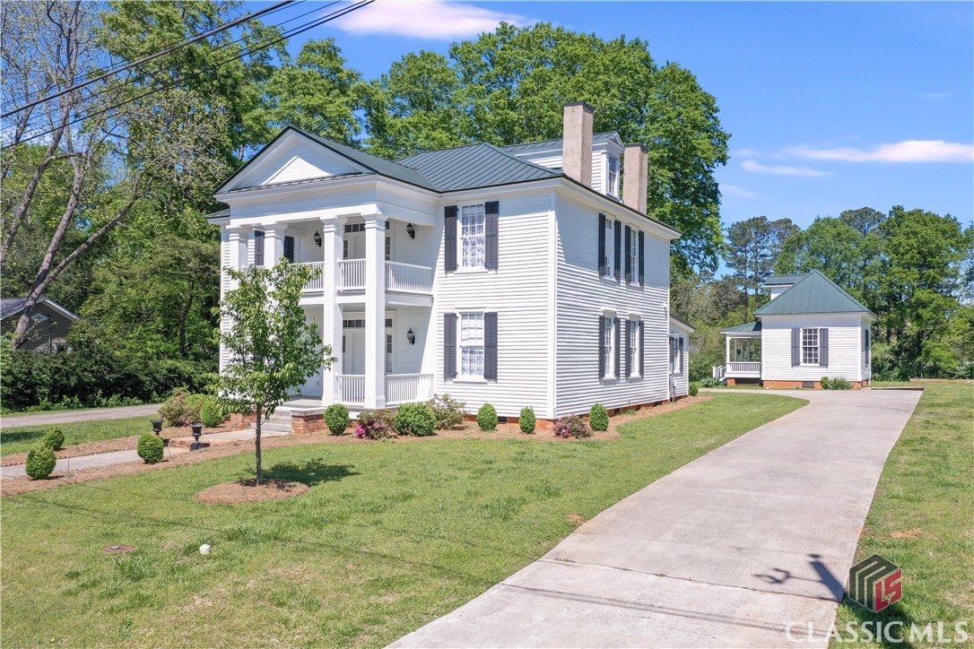 This majestic home was lovingly restored to its former glory in 2018, using historic materials whenever possible to replace missing or damaged original materials. Referred to locally as "The Osborn House," this fully restored home invites you to step back to the 1840's. The main house welcomes you with its wide, covered front porch and ushers you inside to the grand foyer. To the left is a "double parlor" with two fireplaces. To the right is a formal living room and master suite with marble bathroom. The original heart of pine floors have been brought back to life and gleam throughout the home. The kitchen retains elements of the original home as accents but has all modern conveniences. Upstairs there is an en-suite bedroom and two additional bedrooms and a bath. The unfinished third level offers versatile space for finishing or for storage.  In addition, the original "kitchen" is on the back grounds and would make a perfect guest house or office. It dates from the 1890's and was connected to the main house by a porch before the house was moved 50' to the left in 2017.  A carriage house/car shed has been added to house cars or can be used as a pavilion. The Osborn House is not a remodeled house. The professional approach to this restoration restores and recreates the 19th century features of this historic house. Original Federal and Greek Revival designs were restored, and later Victorian additions were treated in such a way as adapting them to the restored/preserved outbuildings. Whenever possible, historic materials were used to replace missing or damaged original materials.