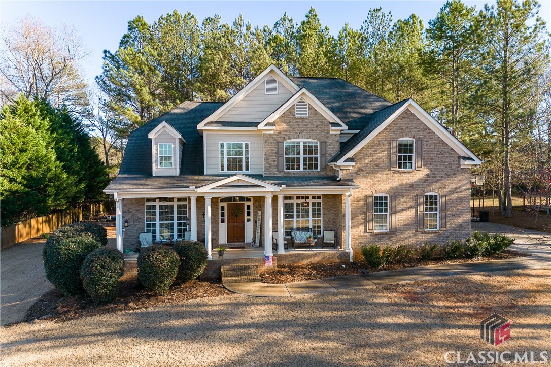 If you are looking for a spacious, traditional style home in the award winning North Oconee School district, then look no further!  This mostly brick home opens into the foyer which is flanked on the right by the formal dining room and on the  left by a space which could be used for a  home office, sitting room, or additional media room.  Hardwood flooring spans the majority of the main level including the two story living room and the kitchen with granite countertops, a center island, and tile backsplash.  The space from the living room to the kitchen is open while a butler's pantry connects the kitchen to the formal dining room.  A guest suite is situated just off of the living room and also offers hardwood flooring in the bedroom.  The connecting bathroom, which is accessible from the guest bedroom as well as the hallway, offers granite countertops, tile flooring and a tile surround.   The laundry room is also located on the main level with custom cabinetry. Three additional bedrooms, including the owner's suite, and a bonus room are located upstairs.  The bonus room is located to the left at the top of the stairs and would be another ideal space for a home office, classroom, gym, or media room.  The owner's suite is situated at the end of the hall to the right and features a trey ceiling in the bedroom while the ensuite offers his & hers vanities with granite countertops, tile flooring, a soaking tub, and tile shower with glass surround.  The remaining two bedrooms are located in the hallway and are served by the bathroom with dual granite countertop, tile flooring, and tile shower/tub combo.  Located on almost one acre, the rear yard is wooded and private with walking trails, and a pergola area with a firepit.