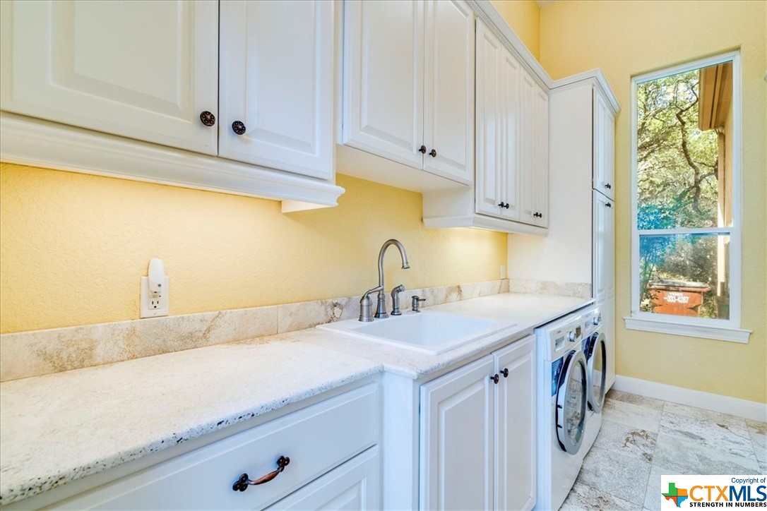 Laundry room with sink.  Washer and dryer convey