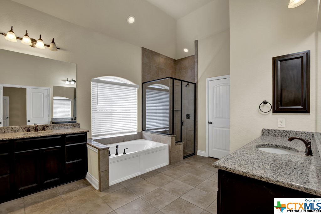 Main bathroom with separate vanities, shower, and garden tub.