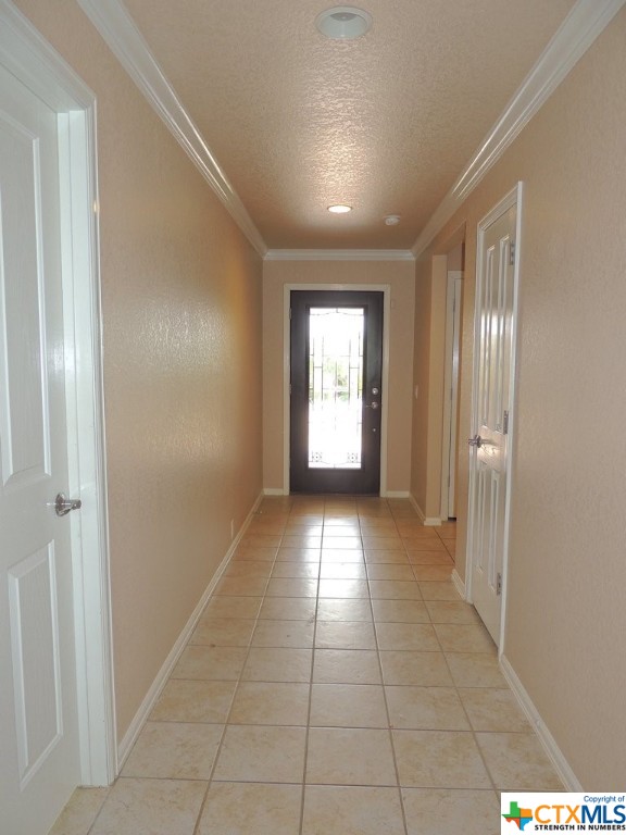 The entry features beautiful ceramic tile floors and crown molding.