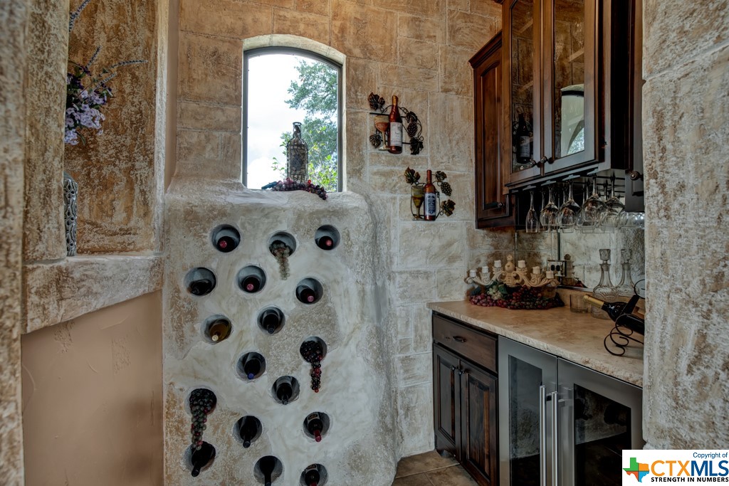 Wine room with coolstone bottle storage, cabinets, and chiller