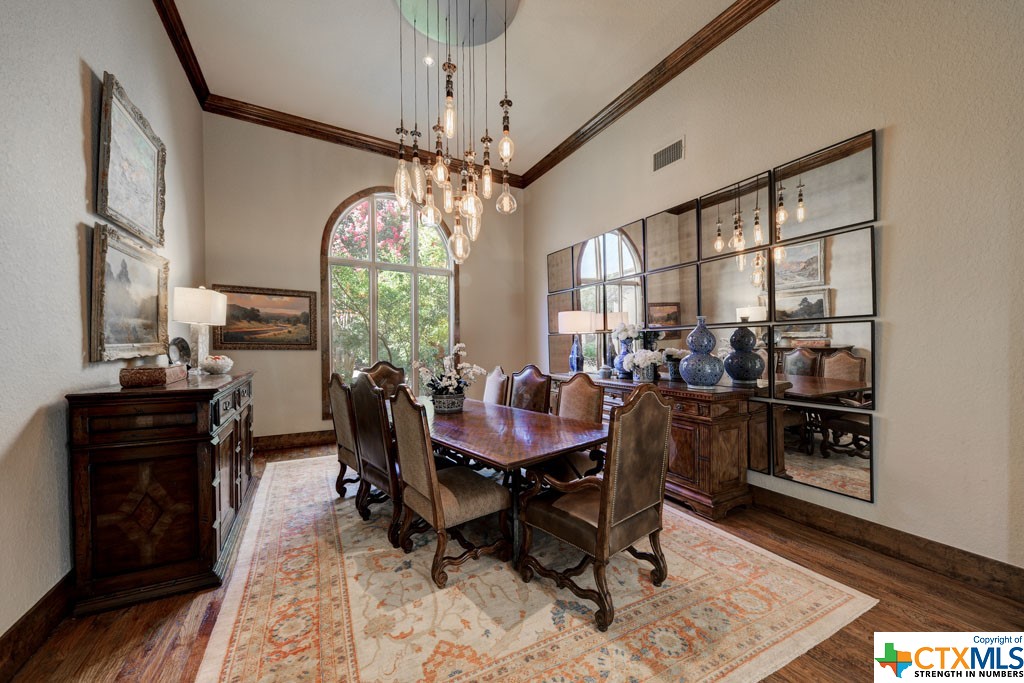 Tantalizing, the only word to describe the ambiance of the formal dining. The winsome light fixture is mesmerizing on its own and is enhanced further by its whimsical reflection. Paired with hand scraped wood floors, this room is of regal stature.