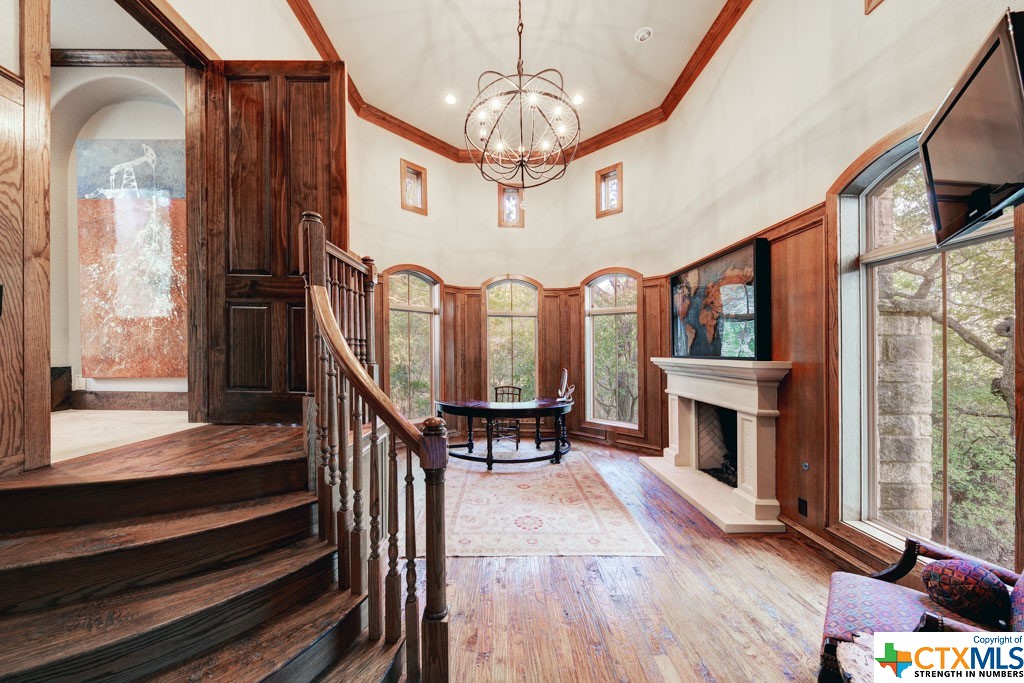 This regal space boasts alluring wood accents throughout. From the hand scraped hard wood floors, to the wood paneled walls encasing superb views, the gas fireplace, and the half staircase, this study maintains and air of nobility while offering a cozy atmosphere encouraging productivity.