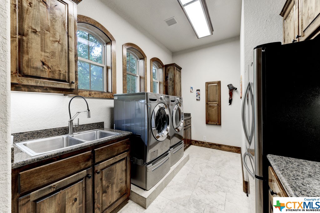 You will want for nothing additional in your laundry room. A built-in ironing board, ample cabinet space, and an industrial sink, this space will easily allow for all your laundry needs!