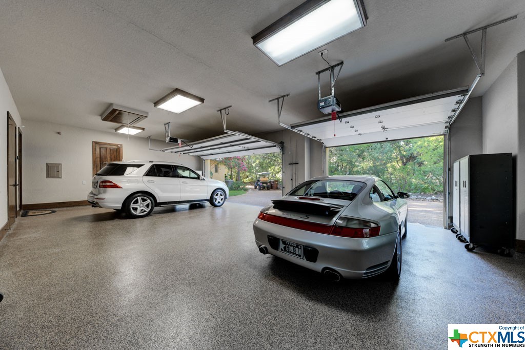 With epoxy flooring, this oversized three car garage hosts built-in cabinets and has a door that opens into the back yard directly behind the dining area.