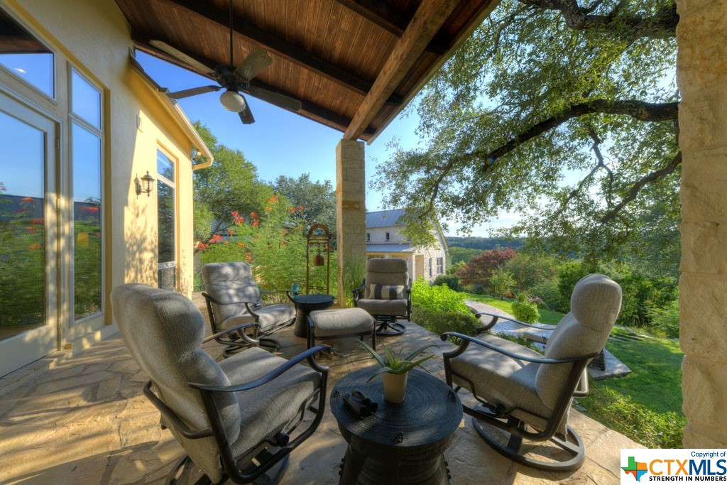 The spacious covered patio allows for multiple seating arrangements with spectacular views of the terraced yard and pool.