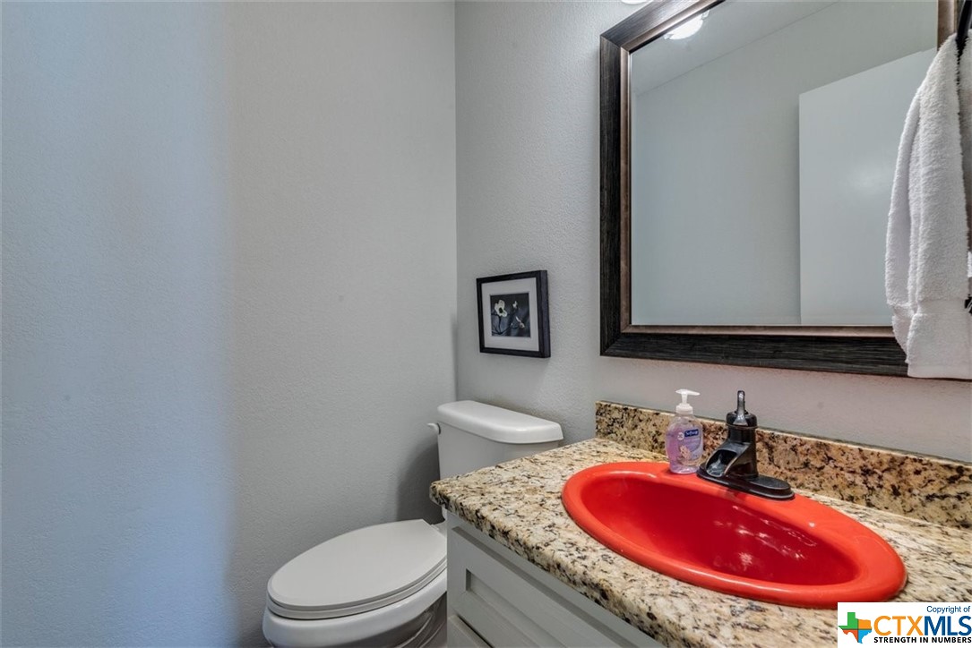 Half bath off kitchen & dining areas features fun original red sink!