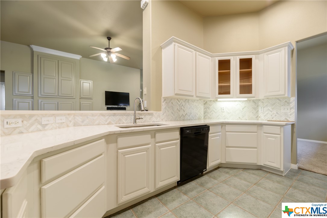Crisp, clean kitchen with white cabinets and granite counters.