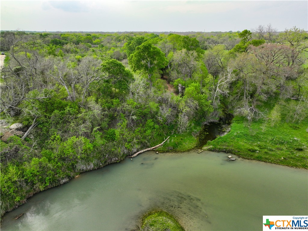 45± acres of endless live water commercial and residential opportunities in a highly desirable part of the state. Conveniently located just a few miles south of Luling, 42± miles from Austin, 53± miles from San Antonio, and about two hours from downtown Houston. The acreage is situated on both sides of Highway 80 and is less than half-a-mile north of I-10. A portion property is within the Luling city limits and could be zoned for commercial use. 250± feet of frontage on the San Marcos River serves as the highlight and also forms the eastern boundary line for the ranch, additionally there is about half-a-mile of wet-weather creek that traverses the landscape, with culvert bridges allowing access throughout the acreage. Municipal water and sewage are also available. This property offers endless recreational and commercial opportunities due to its river frontage and highly sought-after location, is a savvy developer’s dream.