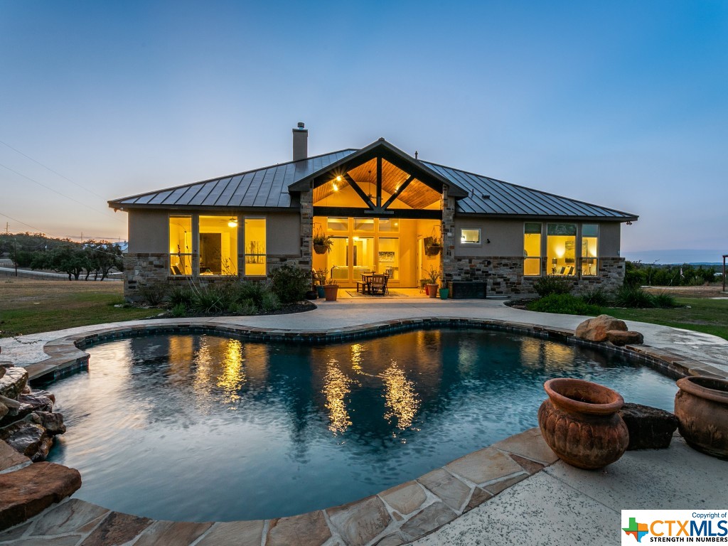 Serenity.  True Texas Hill Country.  Hill top retreat.  Who says you can’t have it all?
Fully fenced in property with automatic entry.  Cross fenced to divide approximately 2-acre pasture for potential livestock.  The most dreamy and exquisite floor to ceiling kitchen that will command everyone's attention.  Texas sized rounded granite island perfect for hosting all your favorite holidays.   Dual granite islands.  Hammered Copper single basin farmhouse sink.  Living room and kitchen entertaining flow seamlessly in this perfectly laid out space.  Stunning stone fireplace with custom wood mantel and gas starter. Wake up to the sunrise glittering off of the pool.  Captivating outdoor views of the backyard oasis through the windows lining the back of the home.  Dog washing station in the 3-car garage. Outdoor wood ceiling covered patio prepped with gas line for outdoor kitchen experience.  End your days in this shady spot perfect for outdoor dining and Texas barbeques.