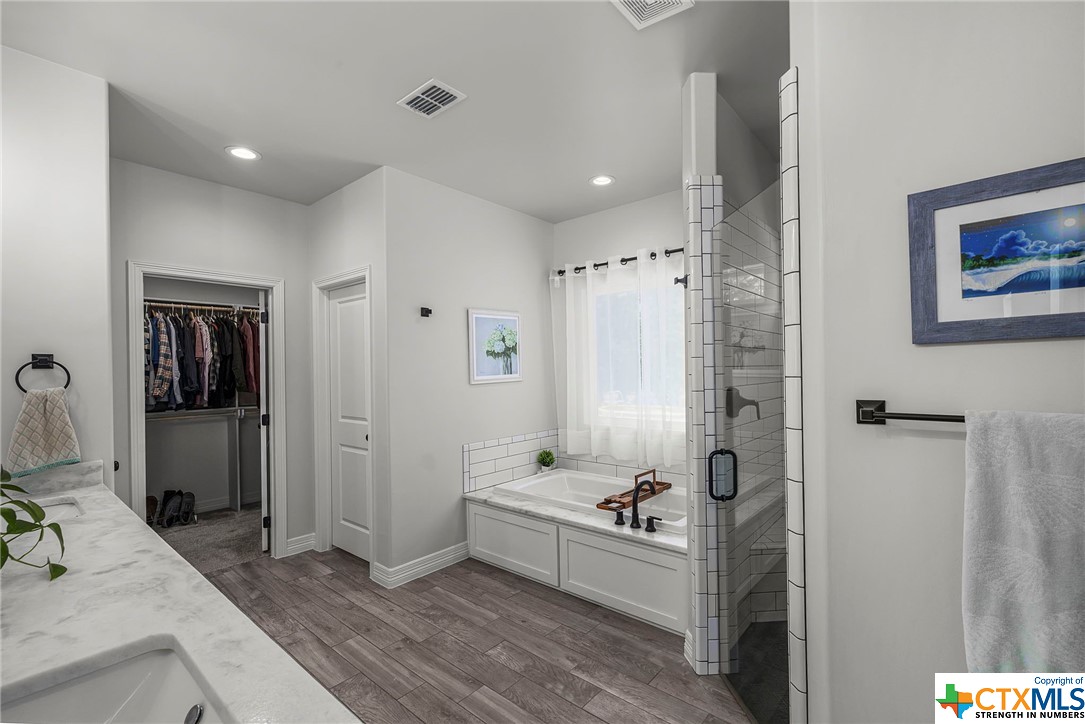 Primary bathroom suite with expansive walk-in closet