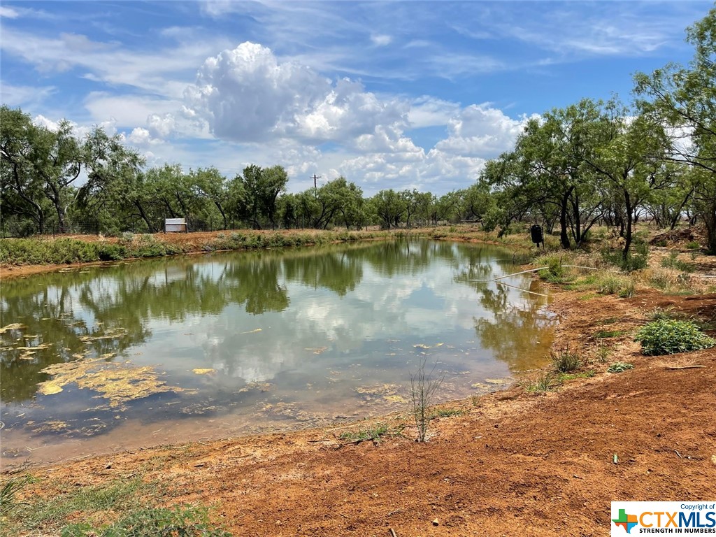 Beautiful, improved property with portion of large, stocked pond fed by well.  Over 320 feet of county road frontage.  Water well and electric service installed.  Some trees and large pasture.  Partially fenced.  Existing Can for entire property#01500000000212