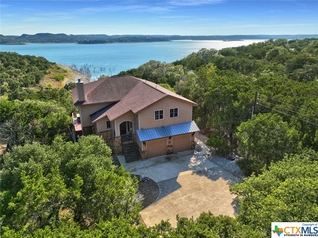 Discover a waterfront oasis on the shores of Canyon Lake! This 1.06-acre lot is perfectly situated to allow uninterrupted views of Canyon Lake. Along the shoreline, built-in benches at the water's edge invite you to relax by the lake, while a stone masonry firepit sets the stage for cozy evenings under the stars. A charming bridge overcomes the terrain, adding character to the property. The exterior is a true gem with dual lake-facing balconies offering breathtaking Canyon Lake views. Yes, Canyon Lake water levels are at a historically low point HOWEVER there are still plenty of water for you to enjoy all the same aquatic activities (boating, swimming, etc.).  The current levels just temporarily may increase the proximity to the lake. Indoors there are two spacious living areas, including a living room with a stone masonry wood-burning fireplace with balcony access to soak in the views. The kitchen is a chef's dream with granite countertops, a center island, bar seating, and stunning lake views that can be enjoyed during every meal. The owner's suite, conveniently located on the main level, offers private outdoor access and captivating Canyon Lake views.