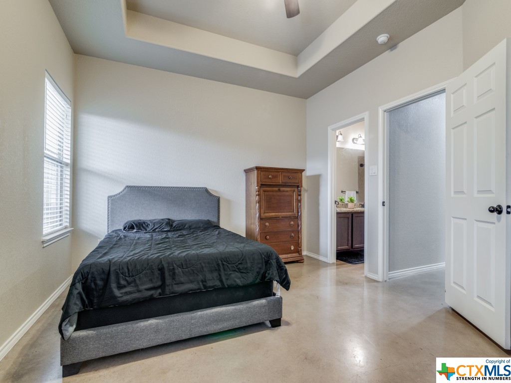 The primary retreat in each unit stands out, boasting a tray ceiling, stained concrete flooring, and an ensuite bath