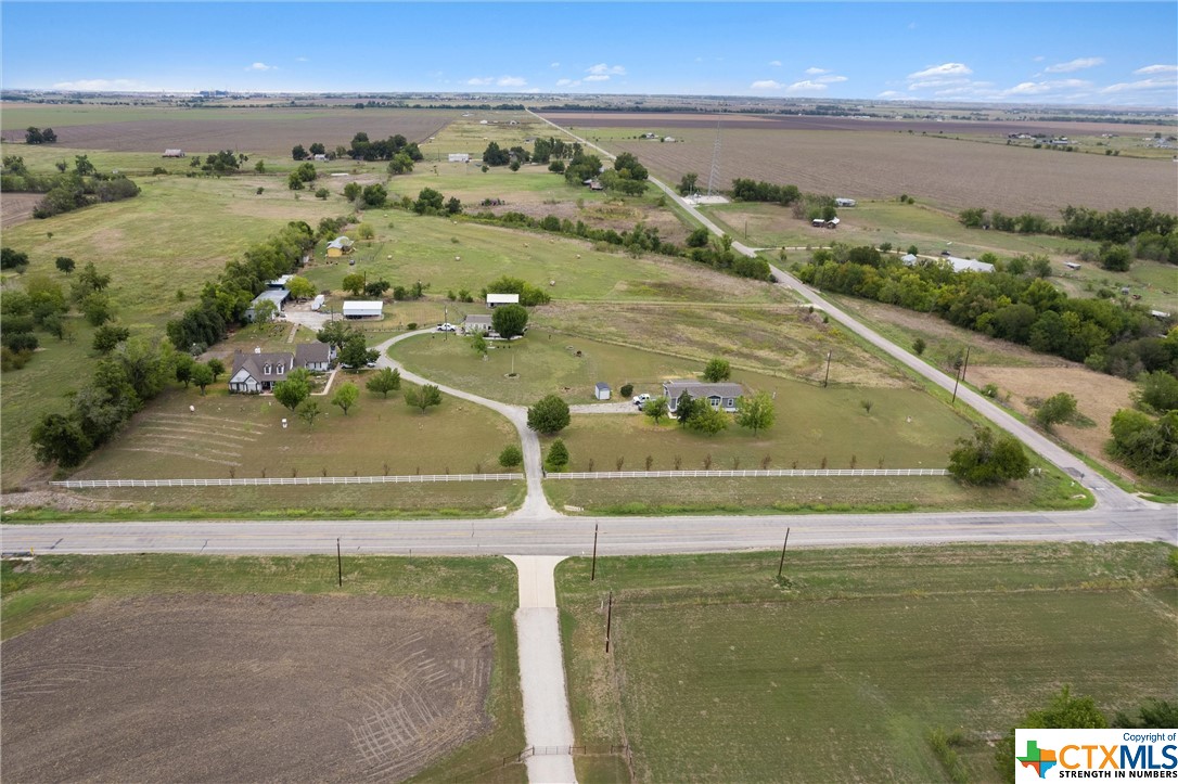 6.2 acre corner lot with NO zoning or restrictions -- 644 ft of frontage along FM 1660 and 435 ft. of frontage along CR 405 -- Currently there is 1 custom home with a garage apartment & 2 manufactured homes on 6.2 acres (2 parcels). Plus a 6-bay workshop with an auto-lift, an RV carport, a horse barn & stalls, 2 storage units and a beautiful white rail fence bordering FM 1660 -- The main house has 3br/2ba, 2210 sf, with a 1br/1ba garage apartment (separate entrance), a wrap-around porch and a covered back patio -- Home #2 has 4br/2ba, 1800 sf and a large covered front porch -- Home #3 has 3br/2ba, 1484 sf and a spacious covered back deck -- Each home is separated with its own driveway, as well as separate mailing addresses, utility meters and septic tanks -- Located less than 5 miles from the Samsung mega plant, and ripe for future growth & development, the possibilities are truly endless for this property and likely very profitable -- Buyer to independently verify all information including but not limited to taxes, schools, square footage, lot size, restrictions, zoning and development.