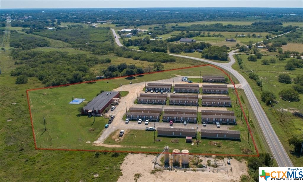 This oilfield housing property on 7.82 acres is located just outside of Cuero on FM 766. There are currently 104 rooms in operation providing lodging for the oilfield workers in the Eagleford Shale. This property is very popular with several oilfield companies and provides guests with food and housing, as needed.     This income-producing property potentially stands to benefit into the future. Built in 2014, this compound consists of 20 - 18x76 ft. lodge buildings with 5 rooms per building. Each studio room has its own bed, recliner, bathroom, closet, TV, and wireless internet. City of Cuero water and sewer for all buildings.     In addition to the housing, there is a commercial kitchen, office building, large dining area with lounge area, open dining room, laundry rooms, lounge and guest media/office area, exercise room, and outdoor basketball court that is lighted and located behind the dining hall. The site was originally designed for 170 rooms and has the infrastructure in place to add more rooms or RVs for additional income. See the company website at ohcuero dot com.     This property is 1.6 miles to Hwy 183 in Cuero, 30 miles to Victoria, 94 miles to downtown San Antonio, 102 miles to San Antonio International Airport.        The 7.82 acres is level land with no floodplain and 800 feet of FM 766 road frontage. A large, manicured yard with several live oak trees wraps around the side and back of the property. Other trees include mesquites along the perimeter and crepe myrtles near the buildings. The property is high fenced along the perimeter and has a security gate at the entrance.