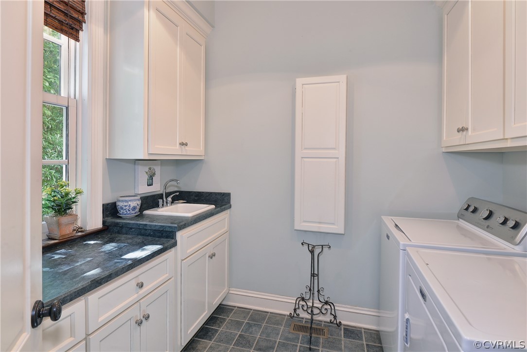Located in the back hallway near the garage, it features washer & dryer, built in cabinets, built-in ironing board, laundry sink, ceramic tile floor, space for hanging hand washed items and separate hanging area for recently ironed items.