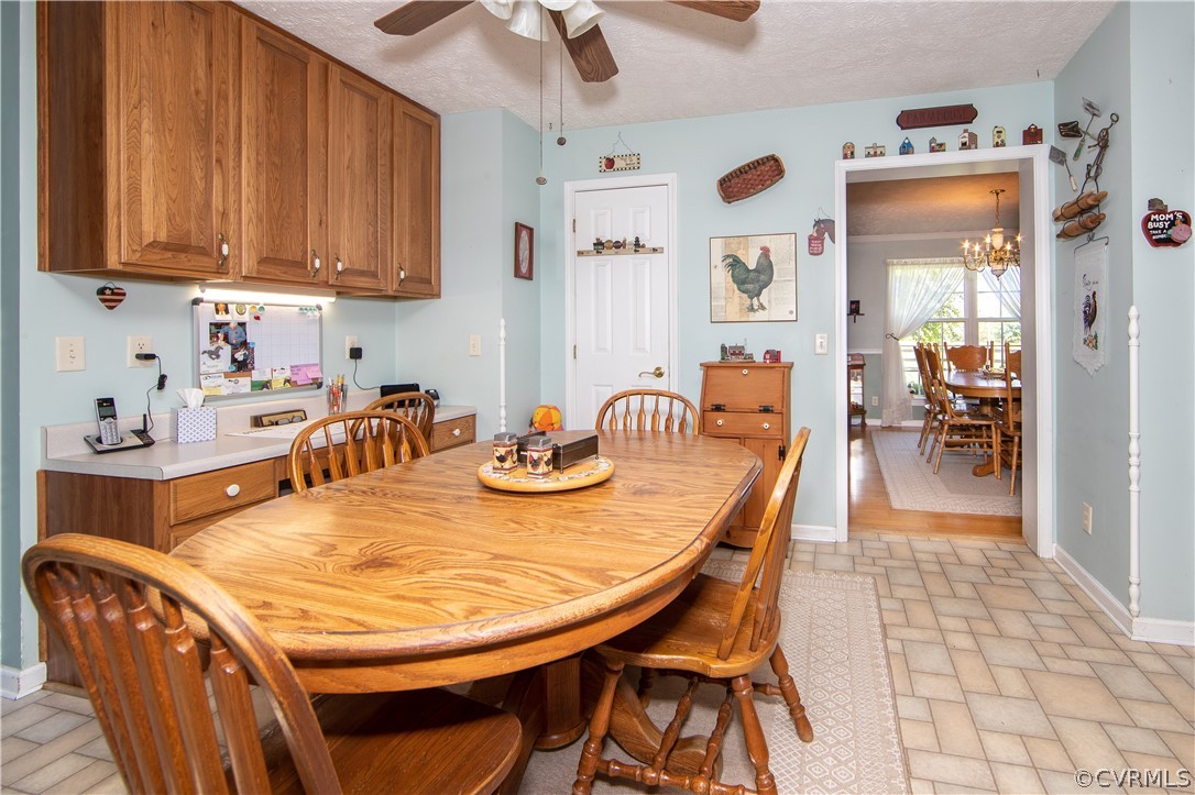 The large eat-in kitchen boasts a large pantry closet, lots of cabinets, and a ceiling fan.