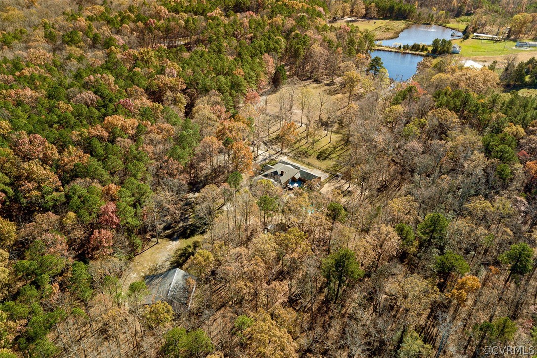 Aerial showing home located between the pond and detached workshop/garage.