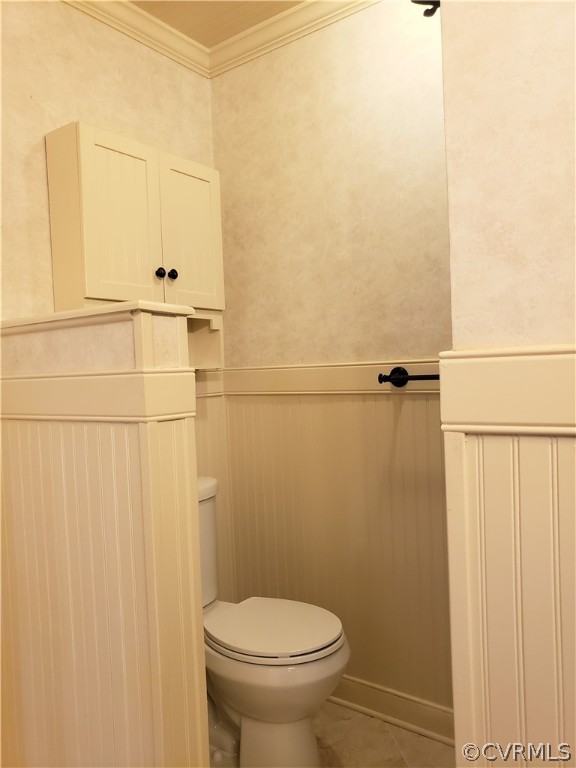 Separated space for toilet with bead board and overhead cabinet for storage