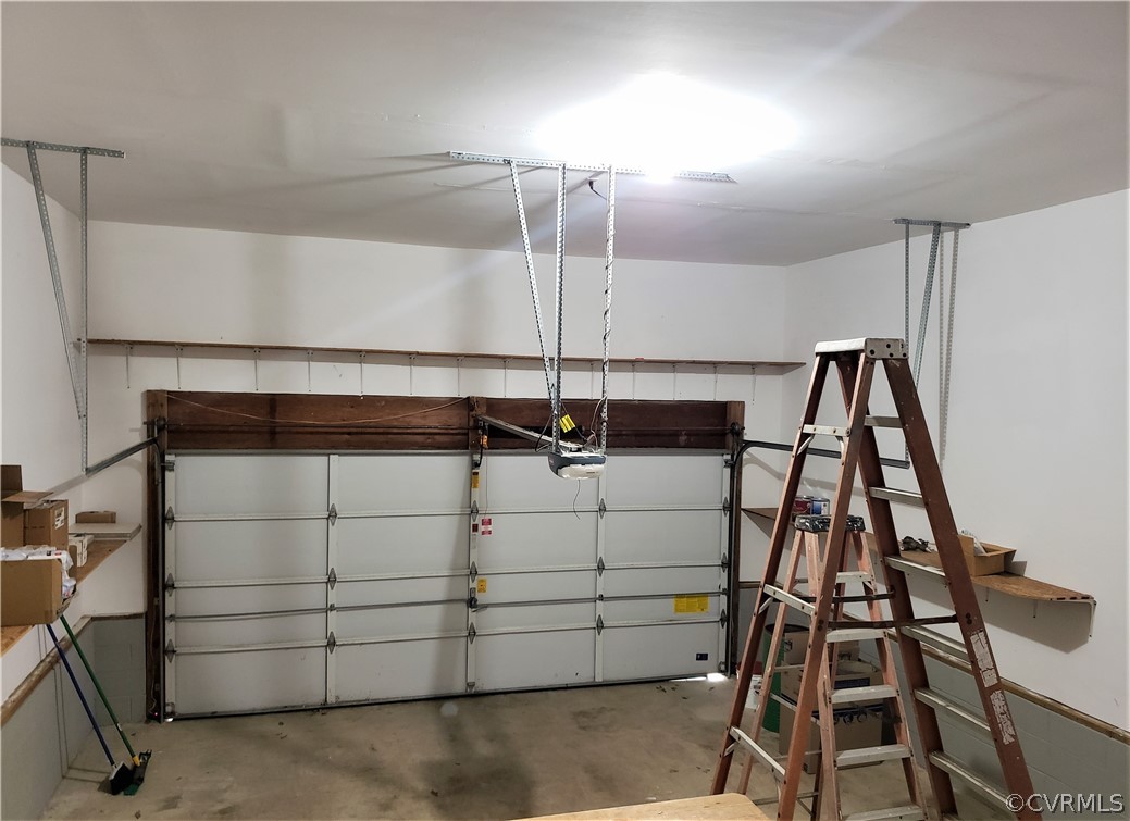 Garage view from Laundry Room with high ceilings for extra storage space. Electric Garage door opener.