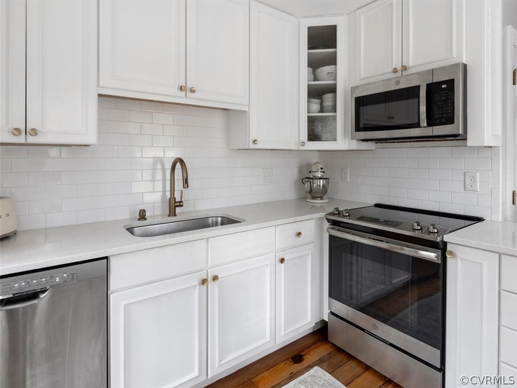 White painted cabinets, hardwood floors, and newer (2020) stainless steel appliances.  Great cabinet space.