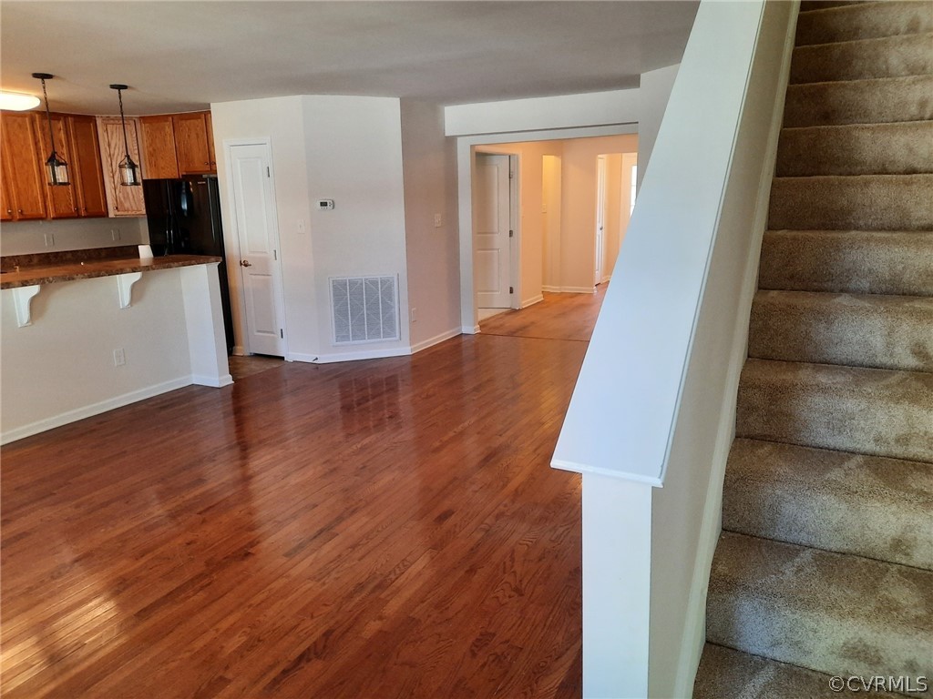 Just painted interior, New Carpet throughout.  Living Room with Hardwood Floor, Island and serving Bar, open to Kitchen and Breakfast Rm, with new carpeted Stairs to the second floor.