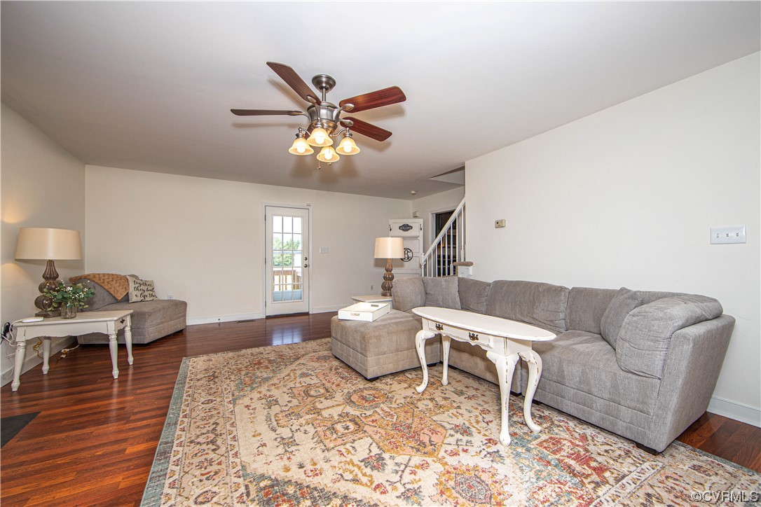 The living room is spacious and features LVP flooring, a ceiling fan and fresh paint.
