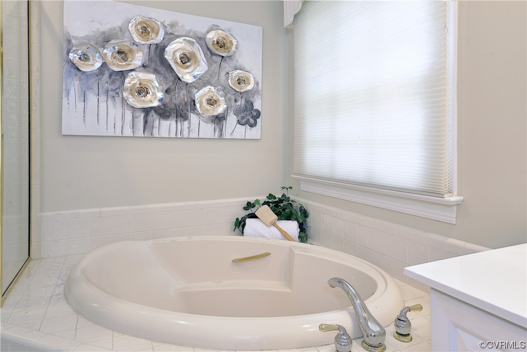 The primary bath has a dual sink vanity, jetted tub, and step-in shower.
