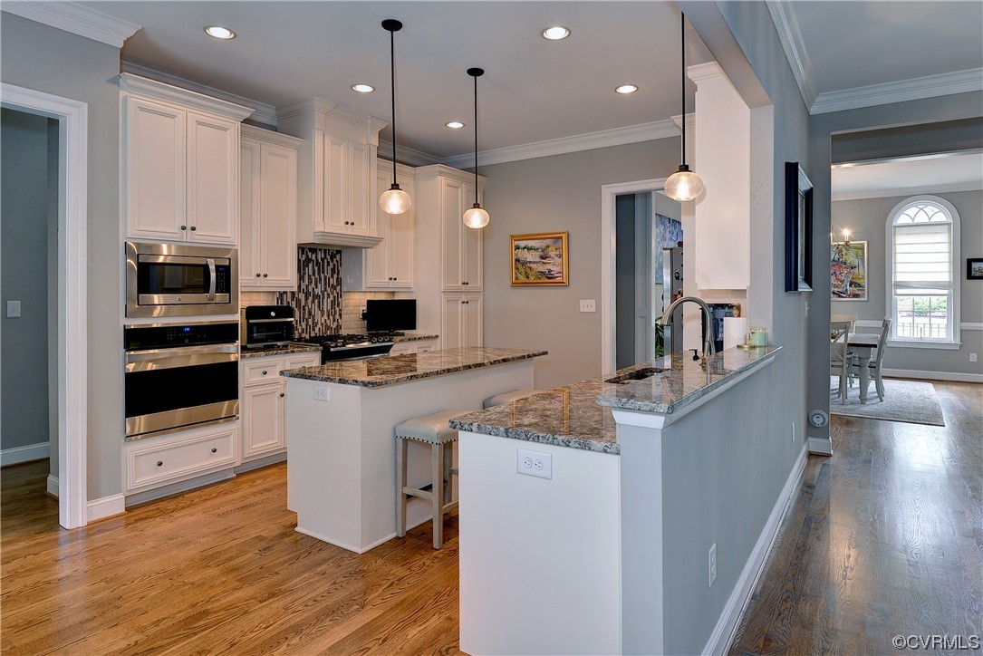 The kitchen features a center island, double ovens, pantry, and gas cooking.