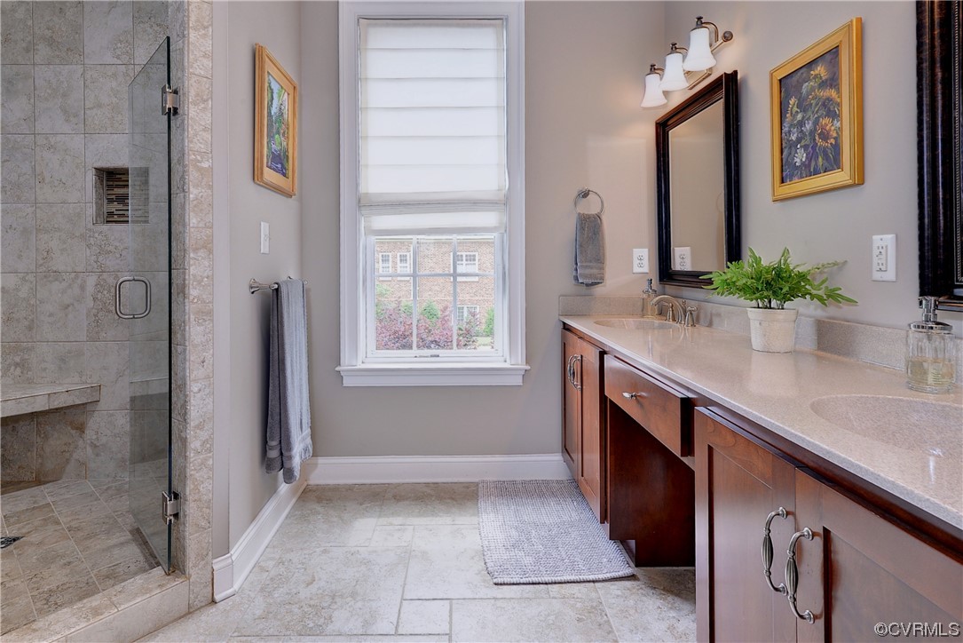 The tiled primary bathroom has a dual sink vanity and a large step-in shower.